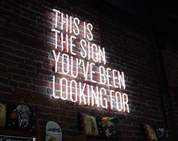 Neon sign on brick wall that says 'The sign you've been looking for
